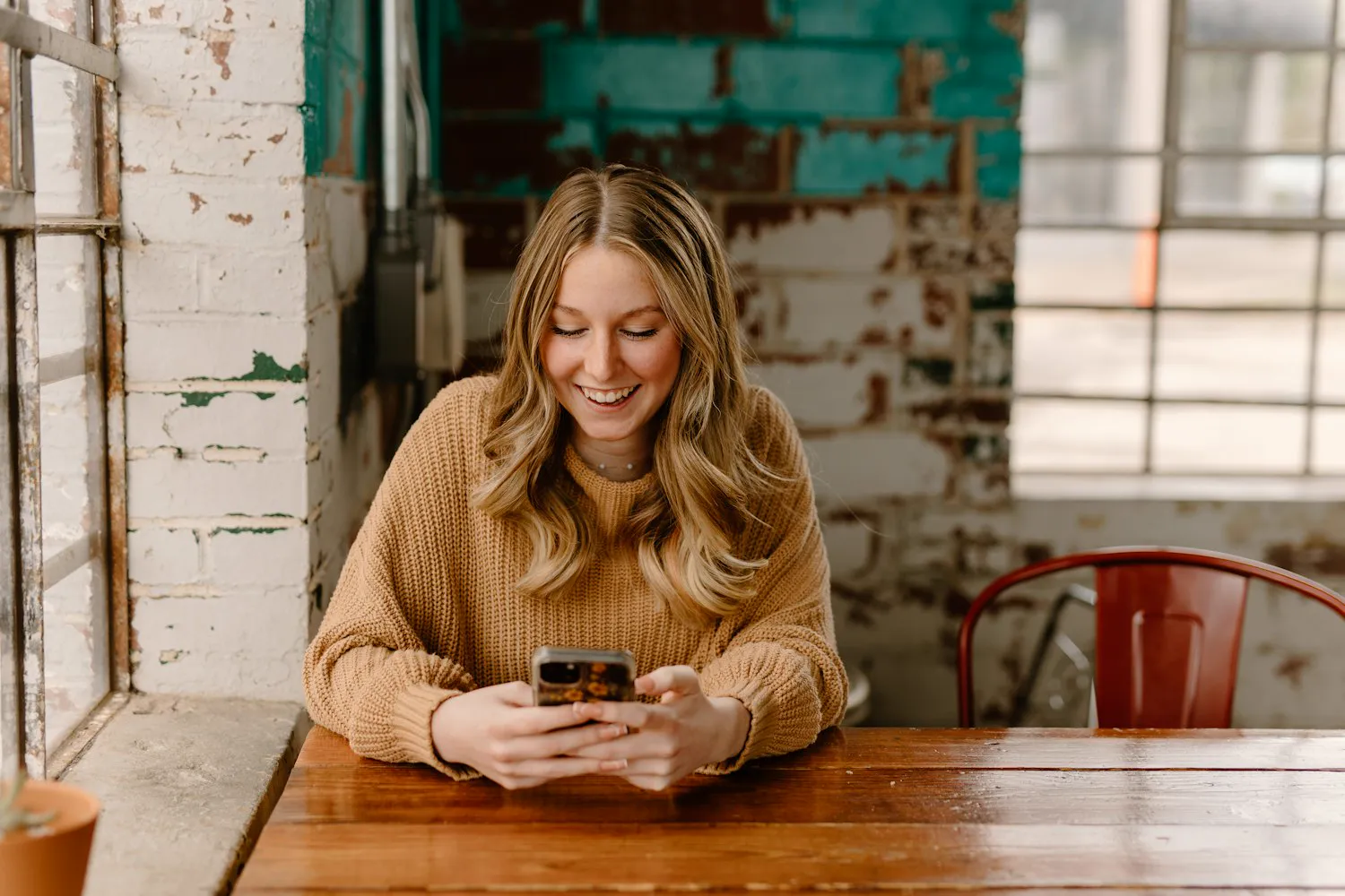 A server smiling at a text message on her phone between shifts